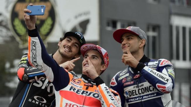 Juara dunia MotoGP 2018, Marc Marquez (tengah), berfoto bersama para juara dunia kelas Moto2 dan Moto3 2018, Francesco Bagnaia (kiri) dan Jorge Martin. [AFP/Javier Soriano]