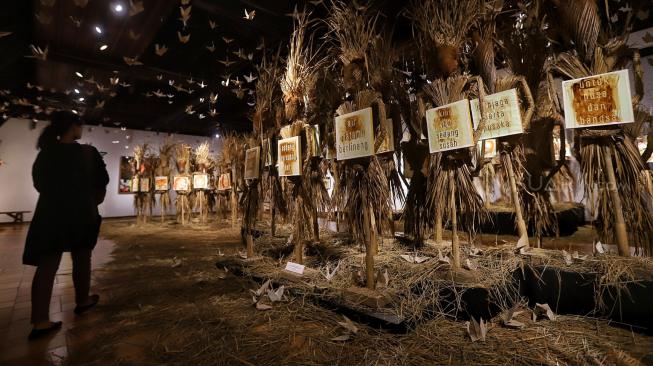 Pengunjung melihat karya Perupa Hari Budiono saat pameran Memedi Sawah di Bentara Budaya Jakarta, Jakarta, Senin (18/2). [Suara.com/Muhaimin A Untung] 