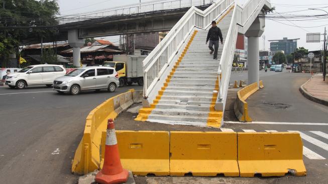 Warga berjalan di Jembatan Penyeberangan Orang (JPO) di kawasan Cawang, Jakarta, Senin (18/2). [ANTARA FOTO/Reno Esnir]