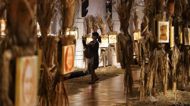 Pengunjung melihat karya Perupa Hari Budiono saat pameran Memedi Sawah di Bentara Budaya Jakarta, Jakarta, Senin (18/2). [Suara.com/Muhaimin A Untung] 