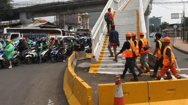 Warga berjalan di Jembatan Penyeberangan Orang (JPO) di kawasan Cawang, Jakarta, Senin (18/2). [ANTARA FOTO/Reno Esnir]