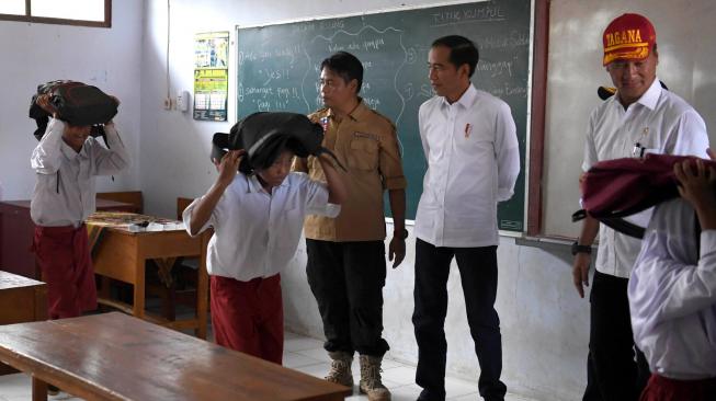 Presiden Joko Widodo (kedua kanan) didampingi Mensos Agus Gumiwang Kartasasmita (kanan) meninjau simulasi terjadinya gempa bumi saat menghadiri pelaksanaan Program Tagana Masuk Sekolah dan Kampung Siaga Bencana di SDN Panimbang Jaya 1, Pandeglang, Banten, Senin (18/2). ANTARA FOTO/Puspa Perwitasari