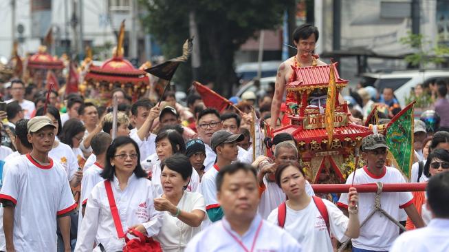 Seorang Tatung berdiri diatas Kio (Tandu) saat arak-arakan perayaan Cap Go Meh di Jakarta, Selasa (19/2). [Suara.com/Muhaimin A Untung]