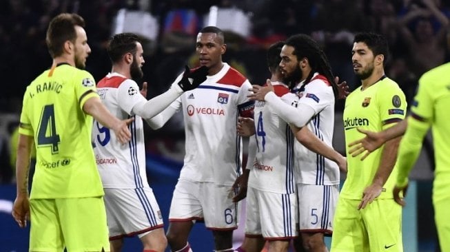 Para pemain Barcelona dan para pemain Lyon bersalaman di akhir pertandingan leg pertama babak 16 besar Liga Champions yang berakhir imbang tanpa gol di Groupama Stadium. JEFF PACHOUD / AFP