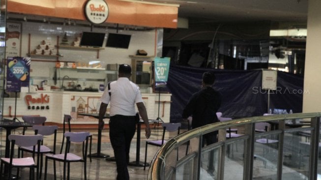 Petugas keamanan berjaga-jaga di sekitar lokasi ledakan pipa gas di lantai 4 food court mal Taman Anggrek, Jakarta Barat, Rabu (20/2). (Suara.com/Fakhri Hermansyah)