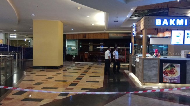 Petugas keamanan berjaga-jaga di sekitar lokasi ledakan pipa gas di lantai 4 food court mal Taman Anggrek, Jakarta Barat, Rabu (20/2). (Suara.com/Fakhri Hermansyah)