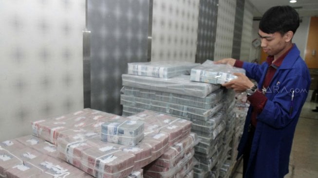 Petugas memeriksa uang di cash Center Plaza Mandiri, Jakarta Pusat, Kamis (21/2). [Suara.com/Fakhri Hermansyah]