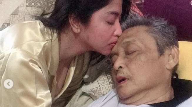 Dewi Perssik mencium kening sang ayah, yang tengah dirawat. (Instagram)