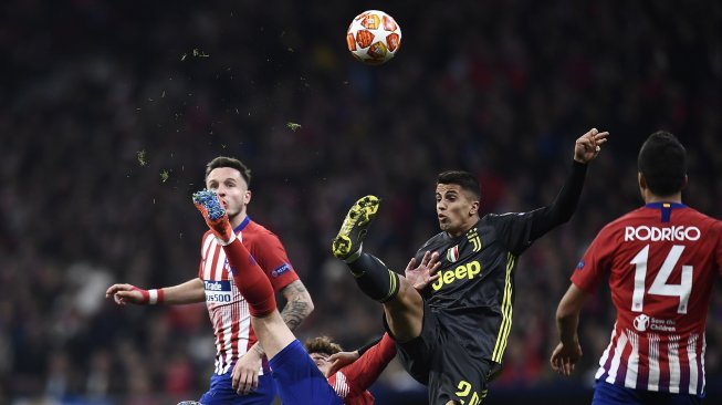 Bek Juventus Joao Cancelo berebut bola dengan striker Atletico Madrid Antoine Griezman pada pertandingan leg pertama babak 16 besar Liga Champions antara Atletico Madrid melawan Juventus di Stadion Wanda Metropolitan, Madrid, Spanyol, Kamis (21/2) dini hari WIB. [OSCAR DEL POZO / AFP]