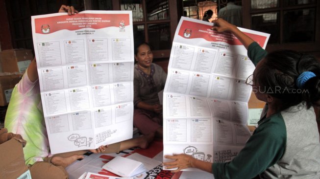 Sejumlah petugas melipat surat suara pemilu di Kantor KPU Jakarta Pusat, Kamis (21/2). [Suara.com/Fakhri Hermansyah]