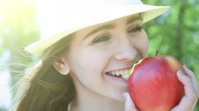 Makan buah apel. (Shutterstock)