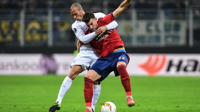 Pemain belakang Inter Milan Miranda (kiri) menahan pemain Rapid Vienna selama pertandingan leg kedua babak 32 besar Liga Europa antara Inter Milan melawan Rapid Vienna di Stadion Guiseppe Meazza, Milan, Italia, Jumat (22/2) dini hari WIB. [Miguel MEDINA / AFP]