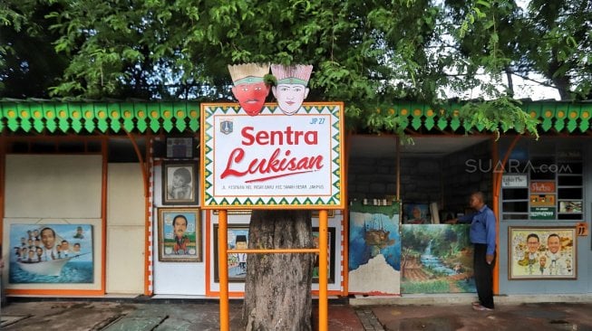 Pelukis sedang berada di kios Sentra Lukisan di kawasan Pasar Baru, Jakarta, Jumat (22/2). [Suara.com/Muhaimin A Untung]