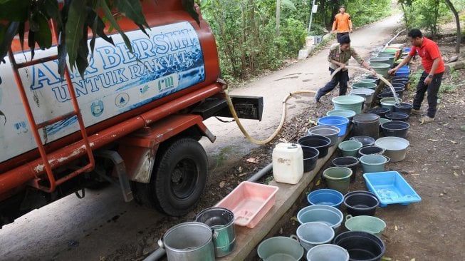 Petugas Badan Penanggulangan Bencana Daerah (BPBD) mendistribusikan air bersih di Desa Sumber Tengah, Bungatan, Situbondo, Jawa Timur, Jumat (22/2). [ANTARA FOTO/Seno]