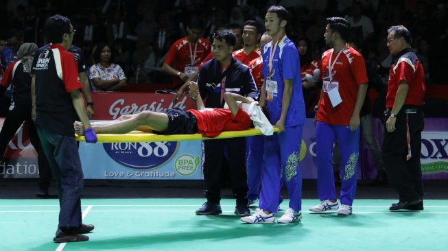 Pebulutangkis tunggal putra Berkat Abadi, Wisnu Yuli Prasetyo, ditandu keluar lapangan lantaran cedera saat melawan Shesar Hiren Rhustavito (PB Djarum) di babak semifinal Djarum Superliga Badminton 2019, Jumat (22/2/2019). [Humas PBSI]