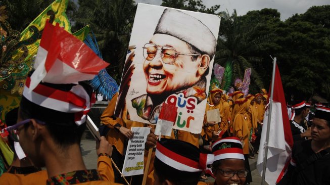 Warga membawa gambar Presiden ke-4 RI Abdurrahman Wahid atau Gus Dur dalam kirab budaya menyambut Haul Gus Dur ke-9 di Solo, Jawa Tengah, Jumat (22/2/19). [Antara/Maulana Surya]