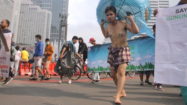 Sejumlah Aktivis melakukan aksi teatrikal bertemakan lingkungan pada Hari bebas kendaraan bermotor (HBKB)  di Bundaran HI, Jakarta Pusat , Minggu (24/2). (Suara.com/Fakhri Hermansyah)