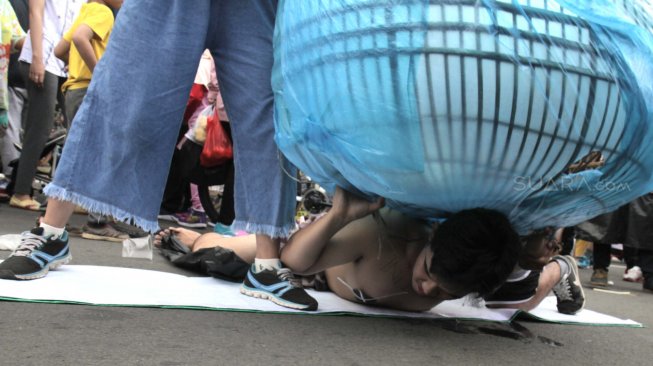 Sejumlah Aktivis melakukan aksi teatrikal bertemakan lingkungan pada Hari bebas kendaraan bermotor (HBKB)  di Bundaran HI, Jakarta Pusat , Minggu (24/2). (Suara.com/Fakhri Hermansyah)