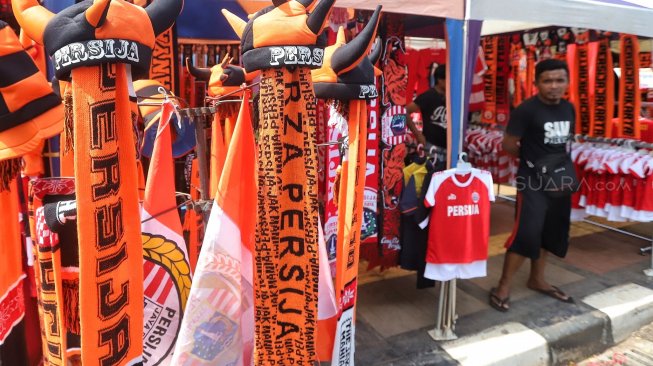 Warga membeli pernak-pernik Persija untuk mendukung Persija di kawasan Gelora Bung Karno, Jakarta, Selasa (26/2). [Suara.com/Muhaimin A Untung]