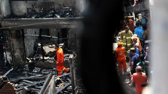 Warga mengumpulkan puing dan sisa barang yang masih bisa dimanfaatkan usai kebakaran di Krukut, Taman Sari, Jakarta Barat, Selasa (26/2). [Suara.com/Arief Hermawan P]