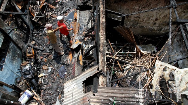 Warga mengumpulkan puing dan sisa barang yang masih bisa dimanfaatkan usai kebakaran di Krukut, Taman Sari, Jakarta Barat, Selasa (26/2). [Suara.com/Arief Hermawan P]