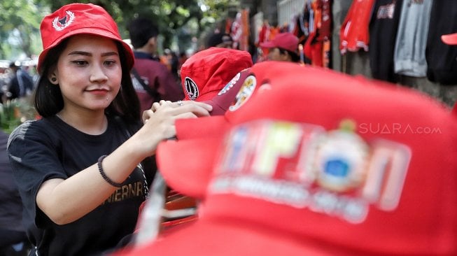 Warga membeli pernak-pernik Persija untuk mendukung Persija di kawasan Gelora Bung Karno, Jakarta, Selasa (26/2). [Suara.com/Muhaimin A Untung]