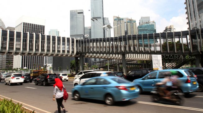 Warga melintas di sekitar Jembatan Penyeberangan Orang (JPO) di kawasan Senayan, Jakarta, Rabu (27/2). [Suara.com/Arief Hermawan P]