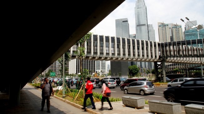 Warga melintas di sekitar Jembatan Penyeberangan Orang (JPO) di kawasan Senayan, Jakarta, Rabu (27/2). [Suara.com/Arief Hermawan P]