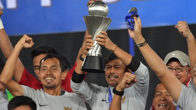 Pelatih Timnas Indonesia U-22 Indra Sjafri (tengah) mengangkat Piala AFF U-22 seusai penganugerahan piala di Stadion Nasional Olimpiade Phnom Penh, Kamboja, Selasa (26/2/2019). Indonesia berhasil menjadi juara setelah mengalahkan Thailand di babak final dengan skor 2-1. ANTARA FOTO/Nyoman Budhiana