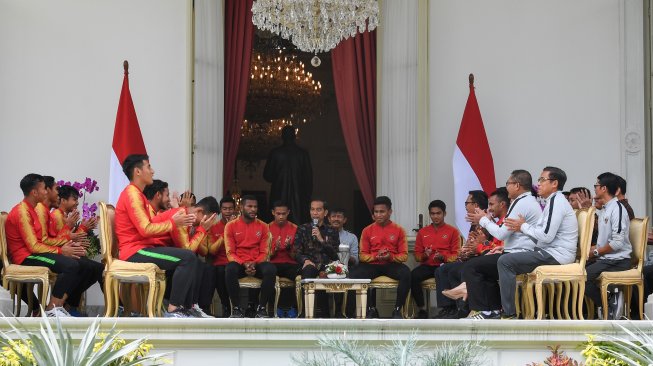 Presiden Joko Widodo (tengah) berbincang dengan pemain Timnas U-22 Indonesia serta ofisial di beranda Istana Merdeka, Jakarta, Kamis (28/2/2019). Presiden memberikan bonus kepada pemain timnas U-22 yang menjadi juara pada kejuaraan AFF U-22 setelah mengalahkan Thailand dengan skor 2-1. Presiden berharap timnas U-22 untuk meningkatkan prestasi selanjutnya dengan menjuarai AFC dan Sea Games. ANTARA FOTO/Wahyu Putro A