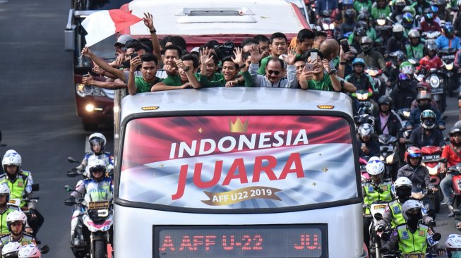 Pemain dan ofisial Timnas U-22 Indonesia menaiki bus tingkat ketika mengikuti konvoi menuju Istana Negara saat melintas di Jalan Sudirman, Jakarta, Kamis (28/2). [ANTARA FOTO/Hafidz Mubarak]
