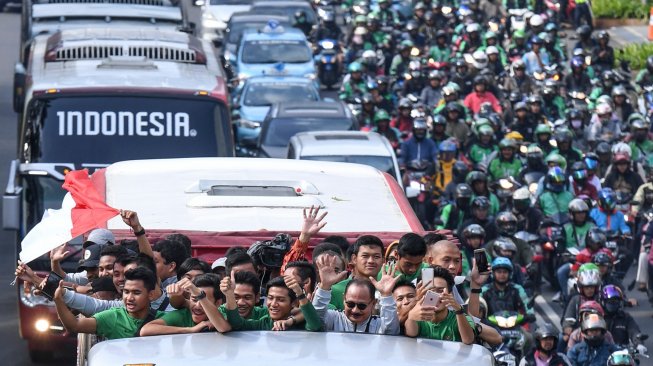 Pemain dan ofisial Timnas U-22 Indonesia menaiki bus tingkat ketika mengikuti konvoi menuju Istana Negara saat melintas di Jalan Sudirman, Jakarta, Kamis (28/2). [ANTARA FOTO/Hafidz Mubarak]
