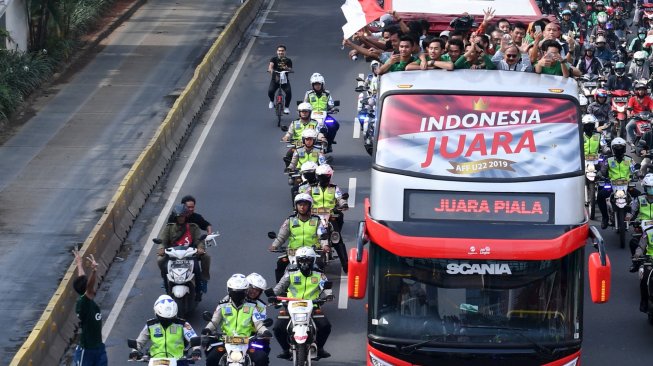 Pemain dan ofisial Timnas U-22 Indonesia menaiki bus tingkat ketika mengikuti konvoi menuju Istana Negara saat melintas di Jalan Sudirman, Jakarta, Kamis (28/2). [ANTARA FOTO/Hafidz Mubarak]
