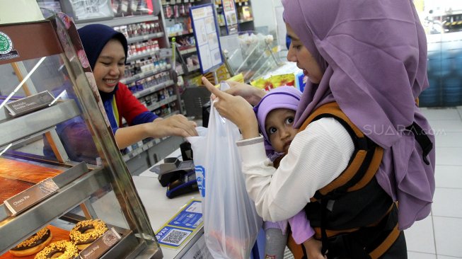 Warga membawa barang belanjaan usai berbelanja di salah satu gerai di kawasan Jakarta Selatan, Jumat (3/1). [Suara.com/Arief Hermawan P]