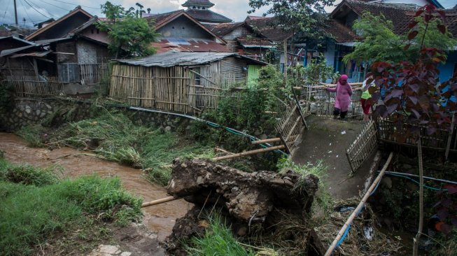 Warga melihat jembatan yang ambruk akibat banjir bandang luapan sungai Cisangkuy di Pangalengan, Kabupaten Bandung, Jawa Barat, Sabtu (2/3). ANTARA FOTO/Novrian Arbi