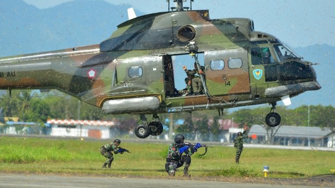 Prajurit Paskhas TNI AU mengamankan lokasi pendaratan saat latihan evakuasi penyelamatan korban pertempuran di pangkalan Lanud Iskandar Muda, Blang Bintang, Aceh Besar, Sabtu (2/3). [ANTARA FOTO/Ampelsa]