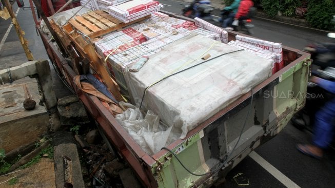 Truk pengangkut batu granit amblas masuk ke dalam lubang saluran air sehingga menutupi sebagian badan jalan di Jalan Pejaten Barat, Pasar Minggu, Jakarta Selatan, Selasa (5/3). [Suara.com/Arief Hermawan P]