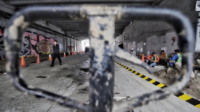 Warga melintas di samping proyek pedestrian Jalan Kendal di bawah Flyover Jalan Sudirman, Dukuh Atas, Jakarta, Selasa (5/3). [Suara.com/Muhaimin A Untung]