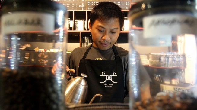 Seorang barista meracik kopi di salah satu kedai kopi di Jakarta, Selasa (5/3). [Suara.com/Arief Hermawan P]