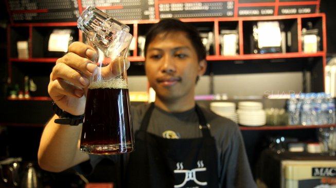 Seorang barista meracik kopi di salah satu kedai kopi di Jakarta, Selasa (5/3). [Suara.com/Arief Hermawan P]