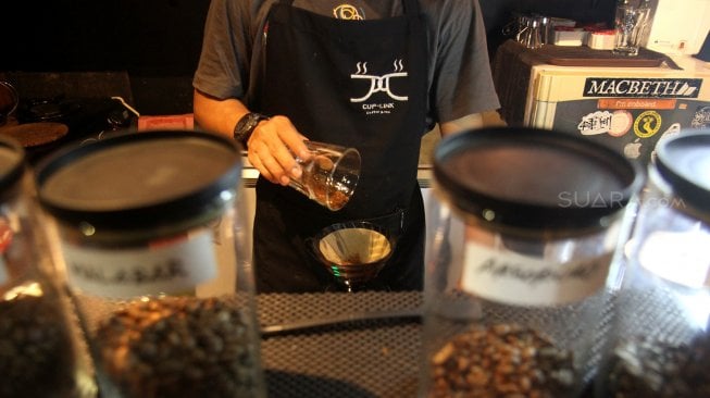 Seorang barista meracik kopi di salah satu kedai kopi di Jakarta, Selasa (5/3). [Suara.com/Arief Hermawan P]