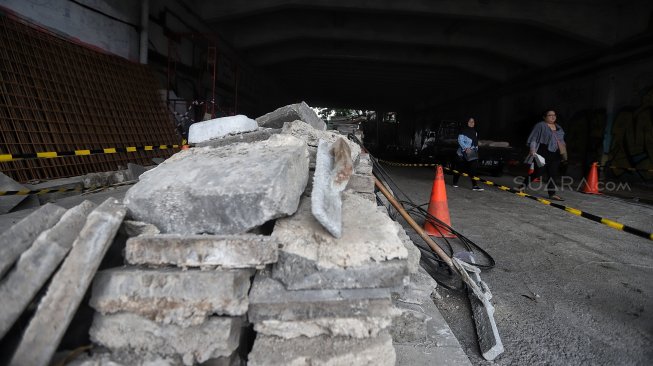 Warga melintas di samping proyek pedestrian Jalan Kendal di bawah Flyover Jalan Sudirman, Dukuh Atas, Jakarta, Selasa (5/3). [Suara.com/Muhaimin A Untung]