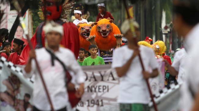 Umat Hindu mengarak Ogoh - ogoh dan sejumlah kesenian lain seperti Ondel - ondel, Barongsai juga Arakan Singa di sepanjang Jalan Cinere Raya, Depok, Jawa Barat, Rabu (6/3). [Suara.com/Arief Hermawan P]