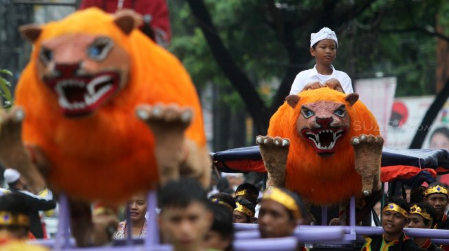 Umat Hindu mengarak Ogoh - ogoh dan sejumlah kesenian lain seperti Ondel - ondel, Barongsai juga Arakan Singa di sepanjang Jalan Cinere Raya, Depok, Jawa Barat, Rabu (6/3). [Suara.com/Arief Hermawan P]