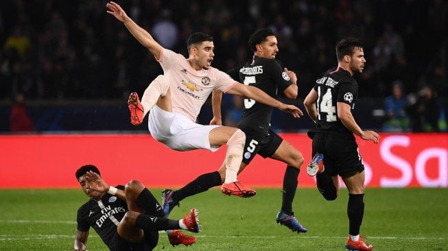 Gelandang Manchester United Andreas Pereira (tengah) ditangani oleh pemain bertahan Paris Saint-Germain Presnel Kimpembe (kiri) pada laga leg kedua 16 besar Liga Champions di Stadion Parc des Princes, Paris, Perancis, Kamis (7/3) dini hari WIB. [FRANCK FIFE / AFP]