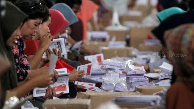 Ratusan warga melakukan pelipatan kertas suara pilpres di Gudang KPU, Cibinong, Kabupaten Bogor, Jawa Barat, Kamis (7/3). [Suara.com/Arief Hermawan P]