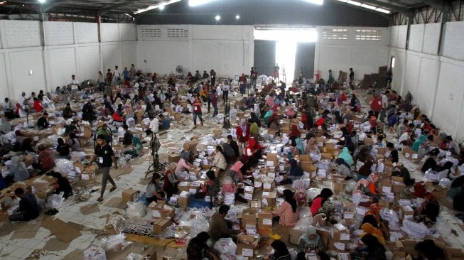 Ratusan warga melakukan pelipatan kertas suara pilpres di Gudang KPU, Cibinong, Kabupaten Bogor, Jawa Barat, Kamis (7/3). [Suara.com/Arief Hermawan P]