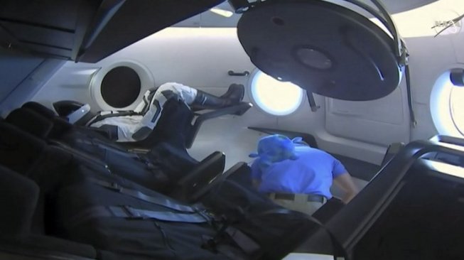 Sebuah boneka bernama Ripley duduk di dalam kapsul Crew Dragon buatan SpaceX. Crew Dragon berhasil berlabuh di stasiun antariksa internasional (ISS) pada 3 Maret lalu. [AFP/NASA TV]