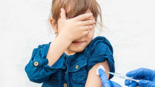 Ilustrasi seorang anak sedang diberi vaksin. [Shutterstock]
