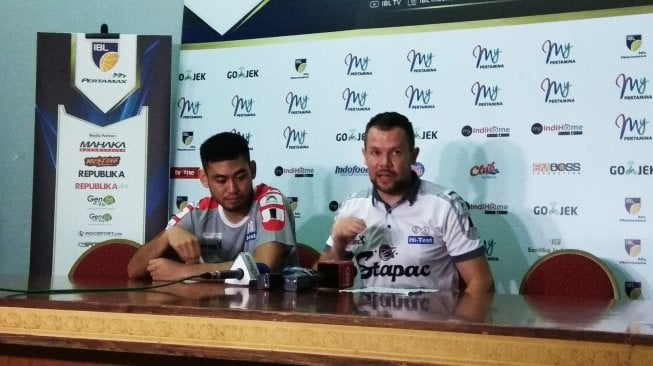 Pelatih Stapac Jakarta, Giedrius Zibenas (kanan) memberikan keterangan dalam jumpa pers usai pertandingan, Sabtu (9/3/2019). (Suara.com/Arief Apriadi)